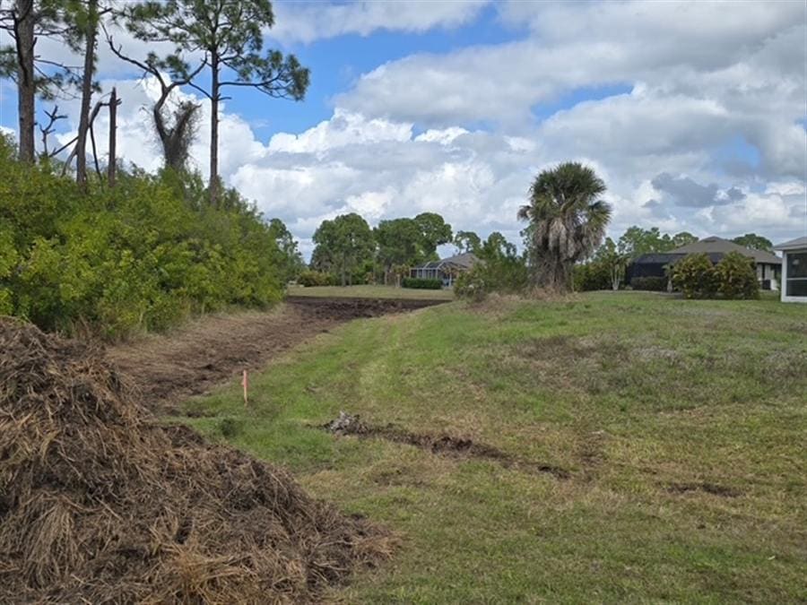 A partially cleared Southwest Florida lot with a debris pile and open ground.