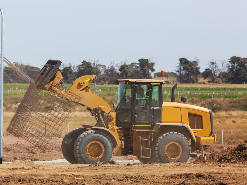 A bulldozer spreading fill dirt across a cleared building site.